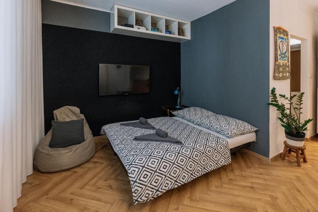 1 dormitorio con 2 camas y TV en la pared en StadiumSide Studio, en Bratislava