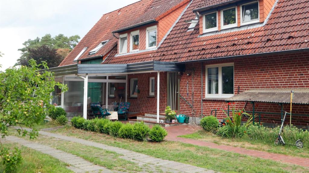 uma casa de tijolos vermelhos com um telhado vermelho em Harbart em Soltau
