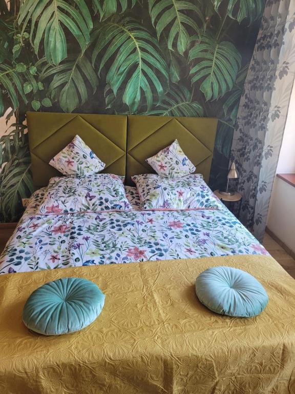 Una cama con dos almohadas azules encima. en APARTAMENTY TR 11 Apartament nr 1, en Olsztyn