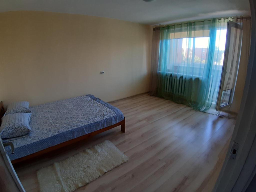 a bedroom with a bed and a large window at Independent apartment in varena in Varėna