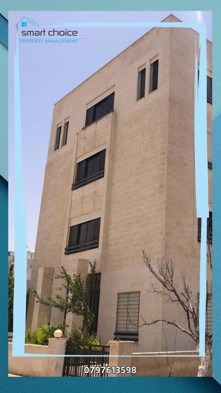 a tall brick building with windows on the side of it at furnished suite airport road جناح مفروش ـ جامعة الشرق الأوسط in Amman