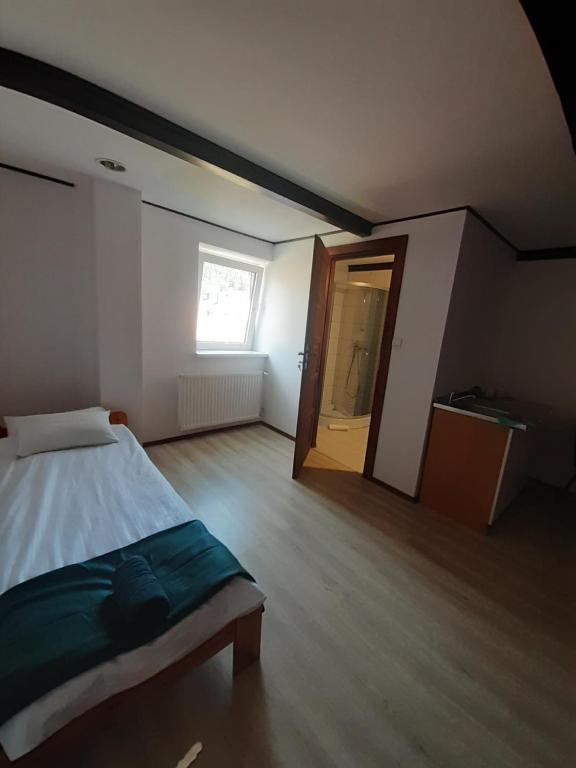 a bedroom with a bed and a window and a door at Apartamenty pod Kicarzem in Piwniczna-Zdrój