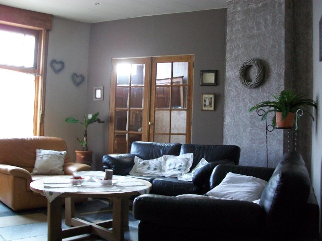 sala de estar con sofá y mesa en Boskanthuisje en Kluisbergen