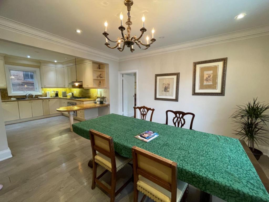 a kitchen and dining room with a green table and chairs at Private Suite in Forest Hill with full kitchen and parking in Toronto