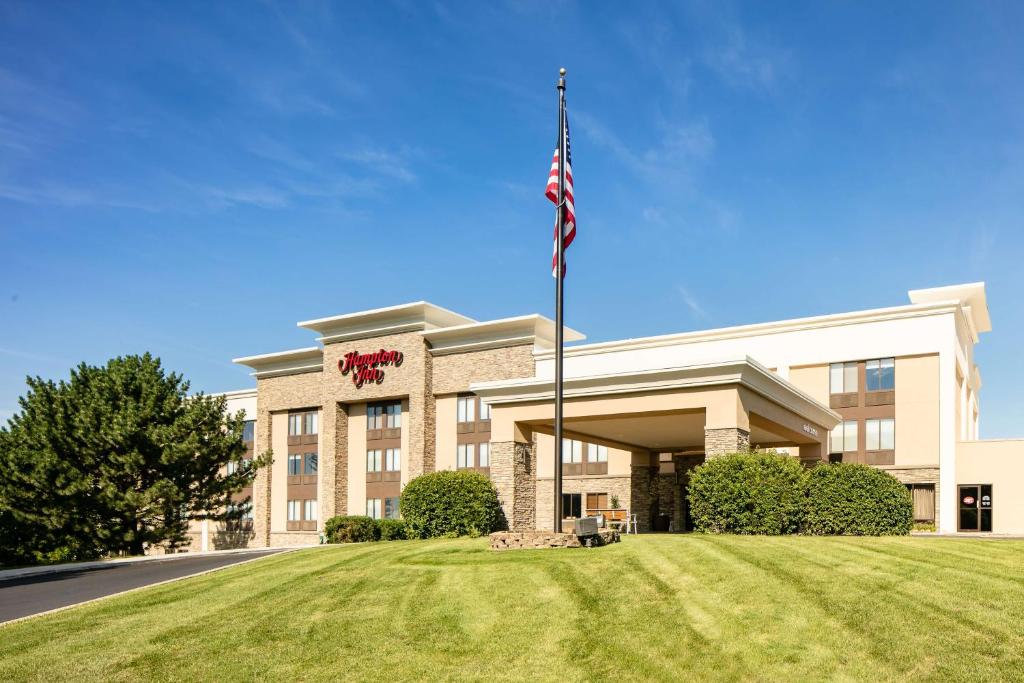 a building with an american flag in front of it at Hampton Inn Iowa City/Coralville in Coralville