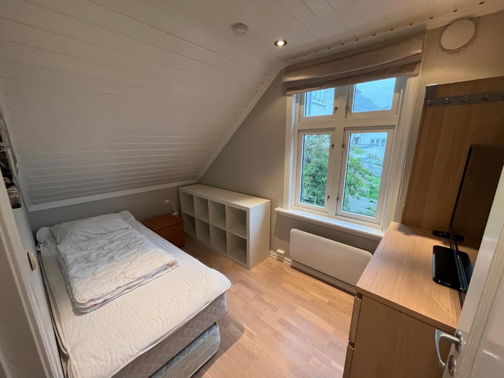 ein kleines Zimmer mit einem Bett und zwei Fenstern in der Unterkunft Måløy City Center - Château Kvalheim in Måløy