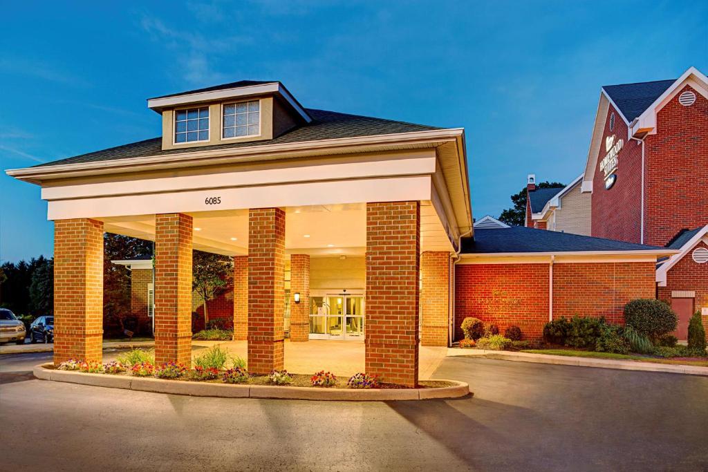 a home with a brick building with a garage at Homewood Suites by Hilton Cleveland-Solon in Solon