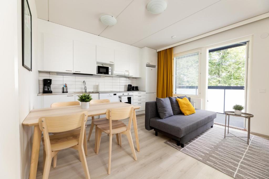 eine Küche und ein Esszimmer mit einem Tisch und einem Sofa in der Unterkunft Hiisi Homes Riihimäki in Riihimäki