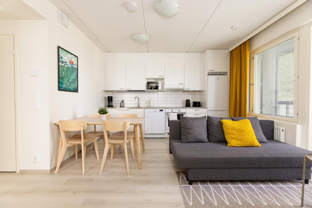 a living room with a couch and a table at Hiisi Homes Riihimäki in Riihimäki