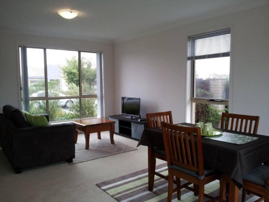a living room with a table and chairs and a television at Entire 2BR sunny house @Franklin, Canberra in Canberra