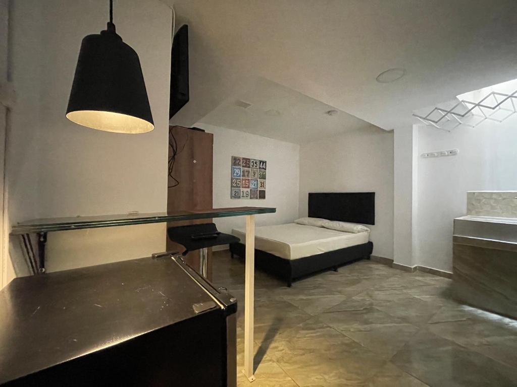 1 dormitorio con 1 cama y 1 mesa en una habitación en Apartamento con aire acondicionado al lado de la Unidad Deportiva de Belén y a 10 minutos de Plaza Mayor - 2, en Medellín