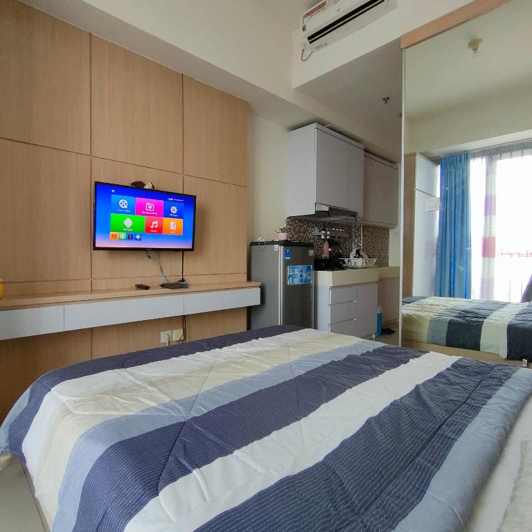 - une chambre avec un lit et une télévision murale dans l'établissement Treepark bsd serpong By SM ROOM, à Dadap