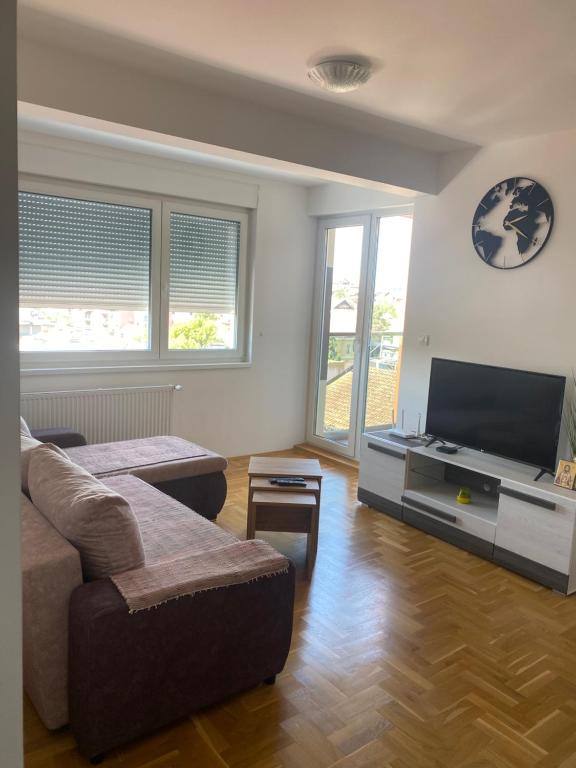 ein Wohnzimmer mit einem Sofa und einem Flachbild-TV in der Unterkunft Hotel centar in Gornji Milanovac