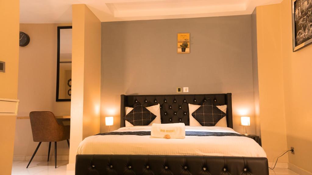 a bedroom with a bed and a desk in a room at BNB Hotel Spa in Abidjan