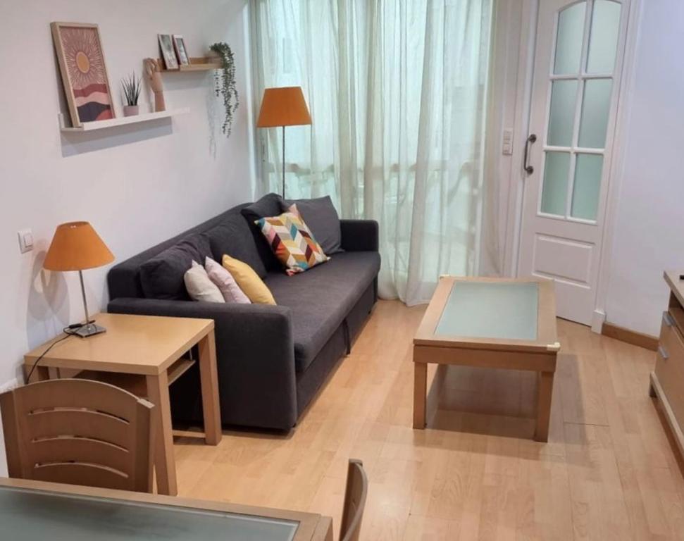 een woonkamer met een bank en een tafel bij Cantabrico playa Grupo AC Gestion in Cádiz