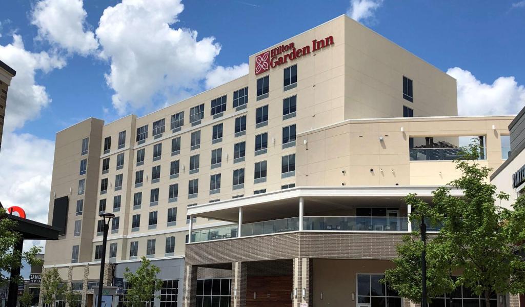 a white building with a sign on top of it at Hilton Garden Inn Charlotte Waverly in Charlotte