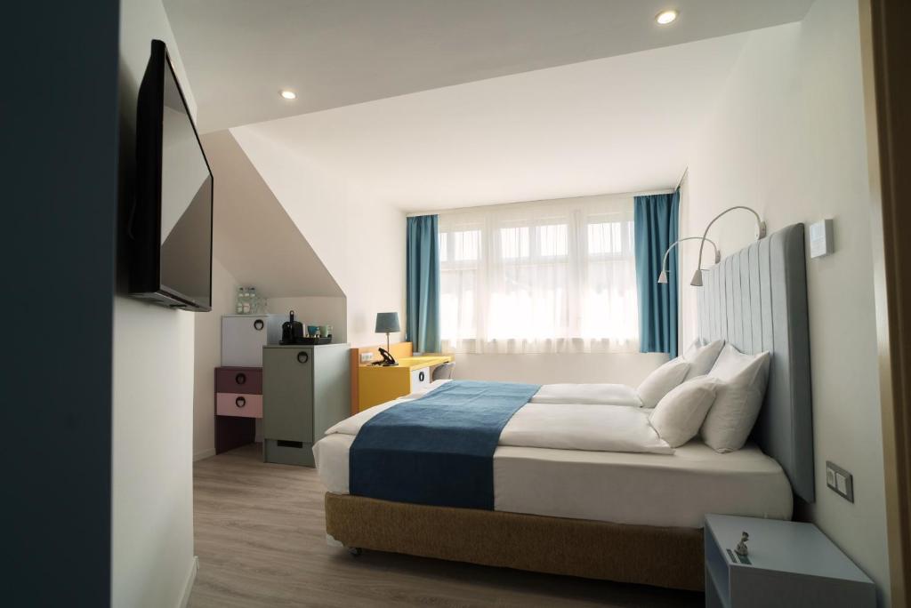 a bedroom with a bed and a television in it at Hotel Civitas in Sopron