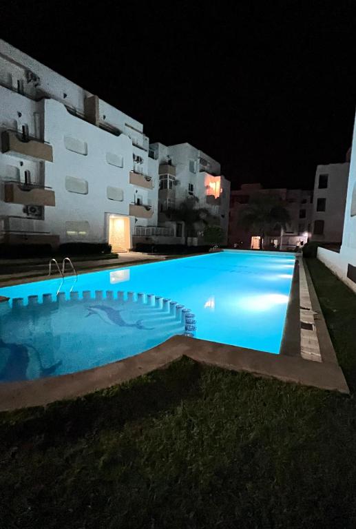 a swimming pool in front of a building at night at The Paradise of ACHAKAR in Tangier