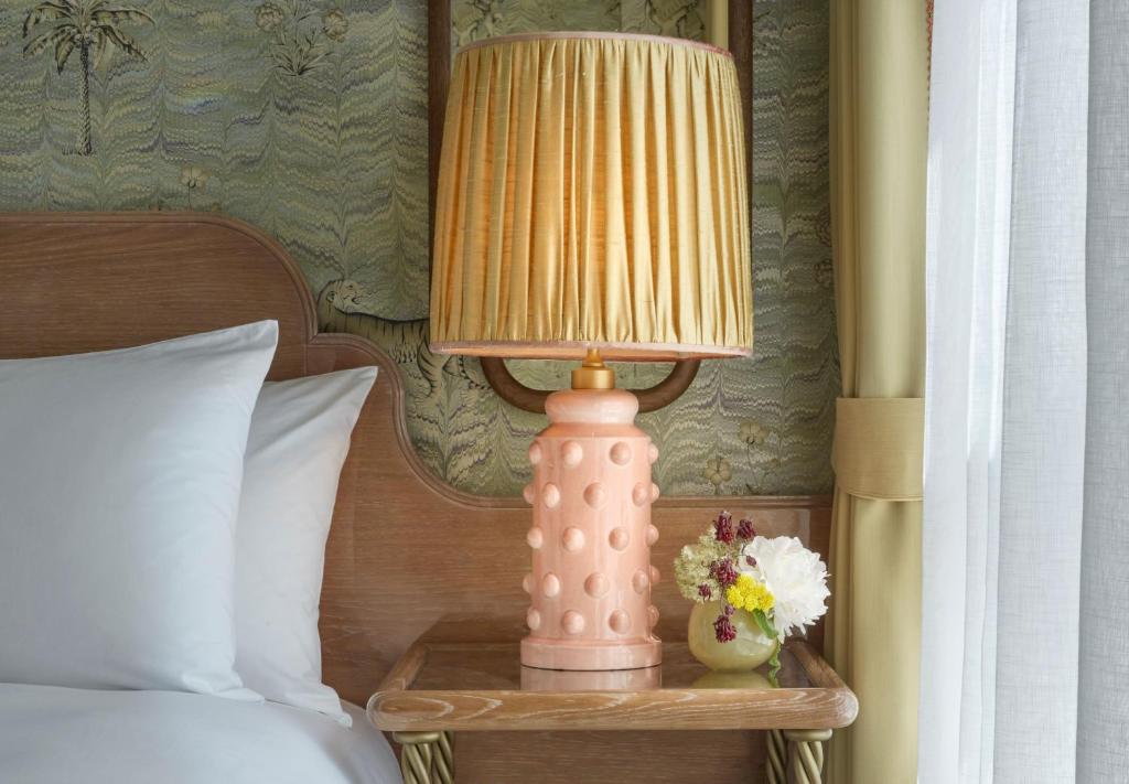 a pink lamp on a table next to a bed at Broadwick Soho in London
