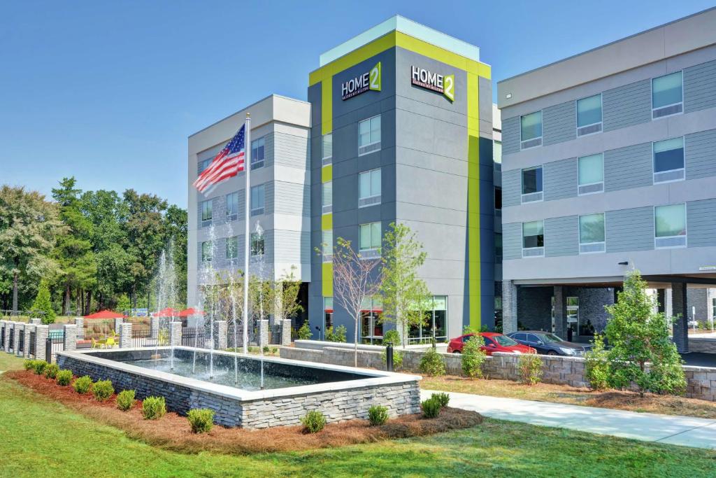 um edifício de escritórios com uma fonte em frente em Home2 Suites By Hilton Charlotte Piper Glen em Charlotte