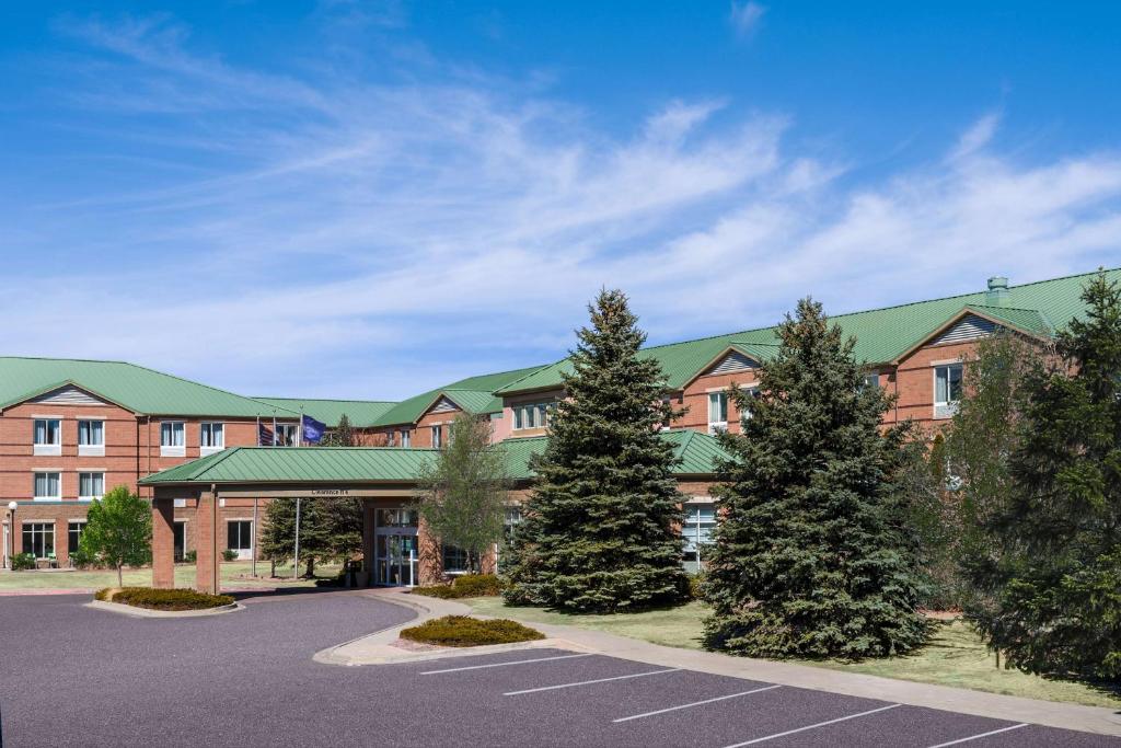 a large building with trees in a parking lot at Hilton Garden Inn Colorado Springs in Colorado Springs