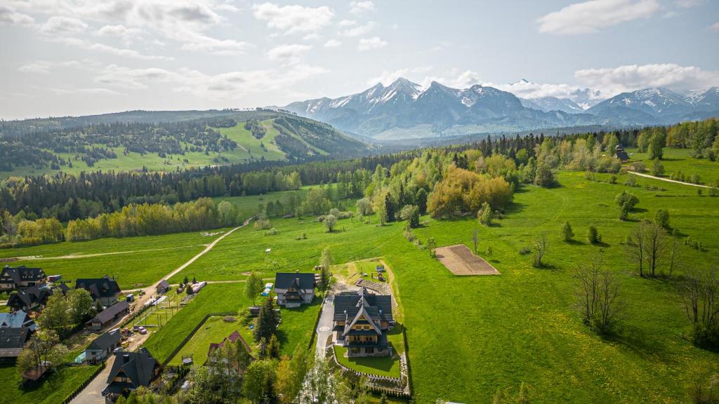 an aerial view of a farm with mountains in the background at Apartamenty Augustynówka in Brzegi