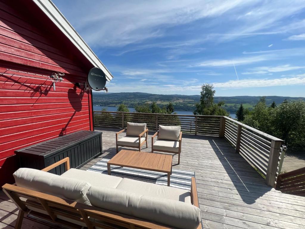 eine Terrasse mit Stühlen und einem Tisch auf einem Haus in der Unterkunft All inclusive villa in Lillehammer