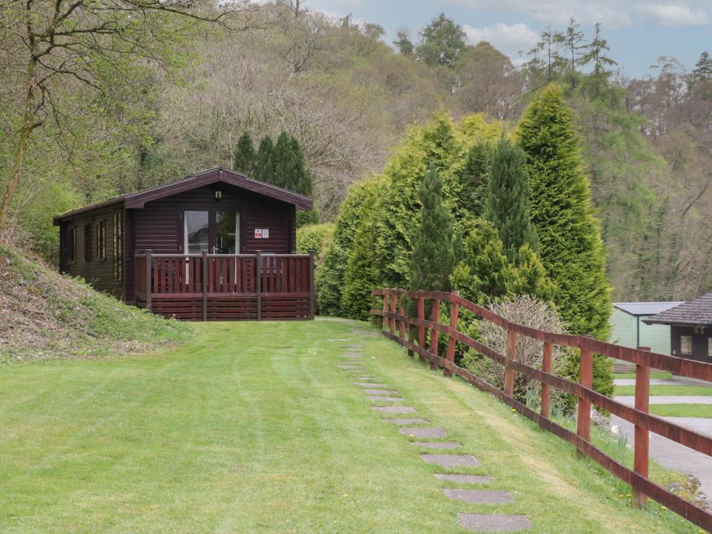 a small cabin on a hill next to a fence at Canadian Cabin 37 in Keswick