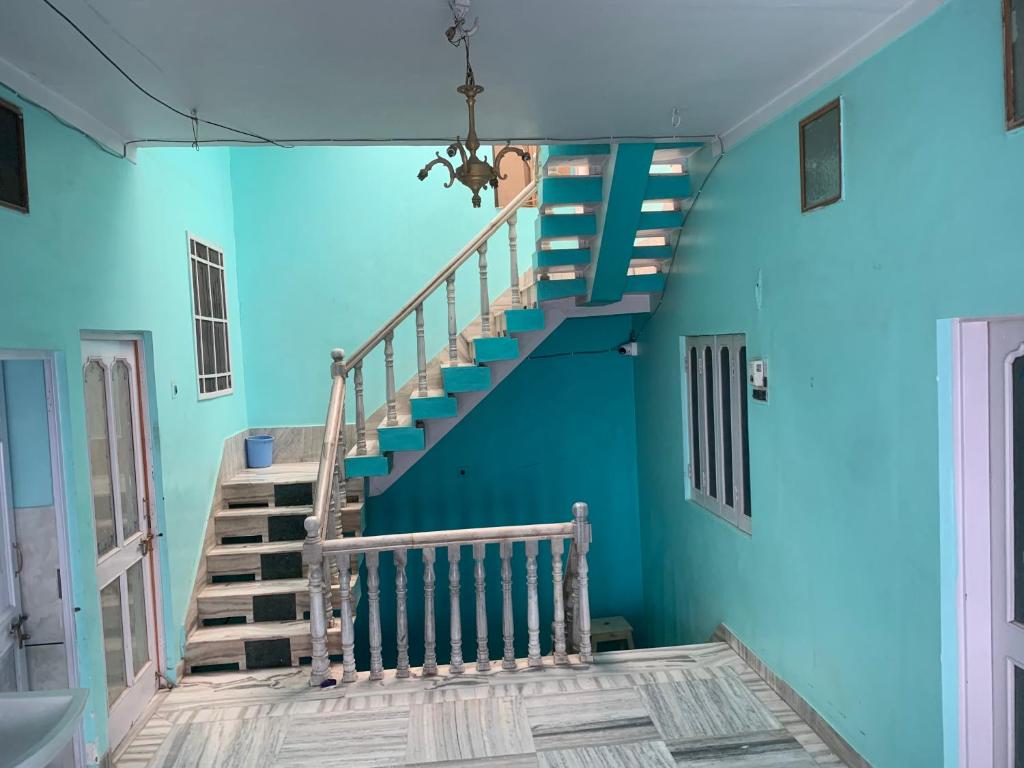 una escalera en una habitación con paredes azules en MOON HAVELI, en Bikaner