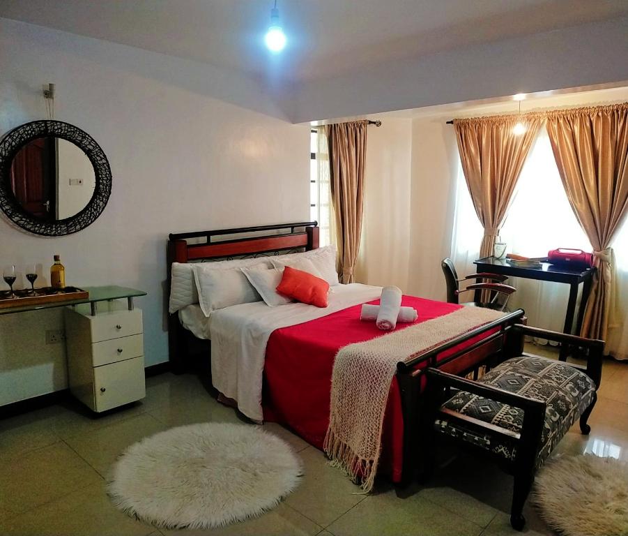 a bedroom with a bed with a red blanket at Beautiful spacious room in Nairobi