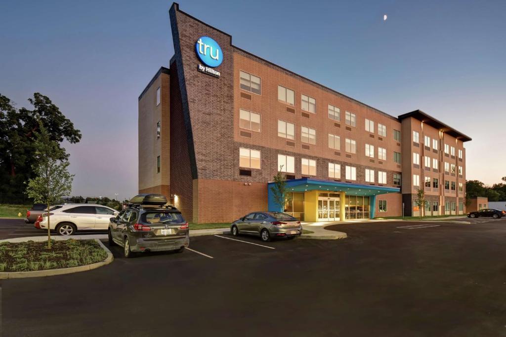 a building with cars parked in a parking lot at Tru By Hilton Cincinnati Airport South Florence in Florence
