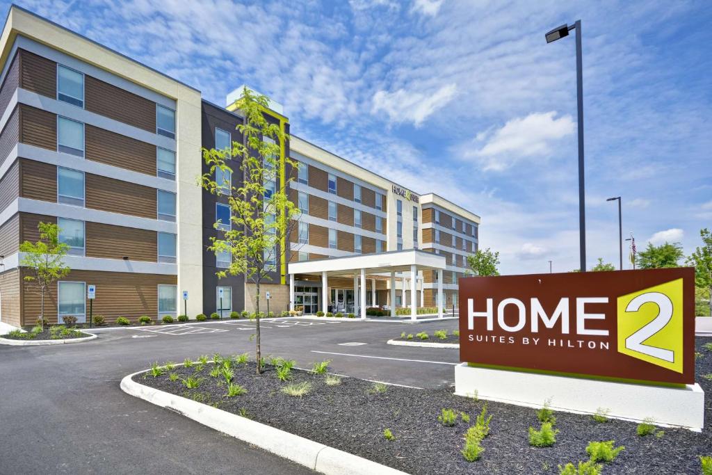 una señal frente a un edificio con suites familiares por misión en Home2 Suites By Hilton Blue Ash Cincinnati en Blue Ash