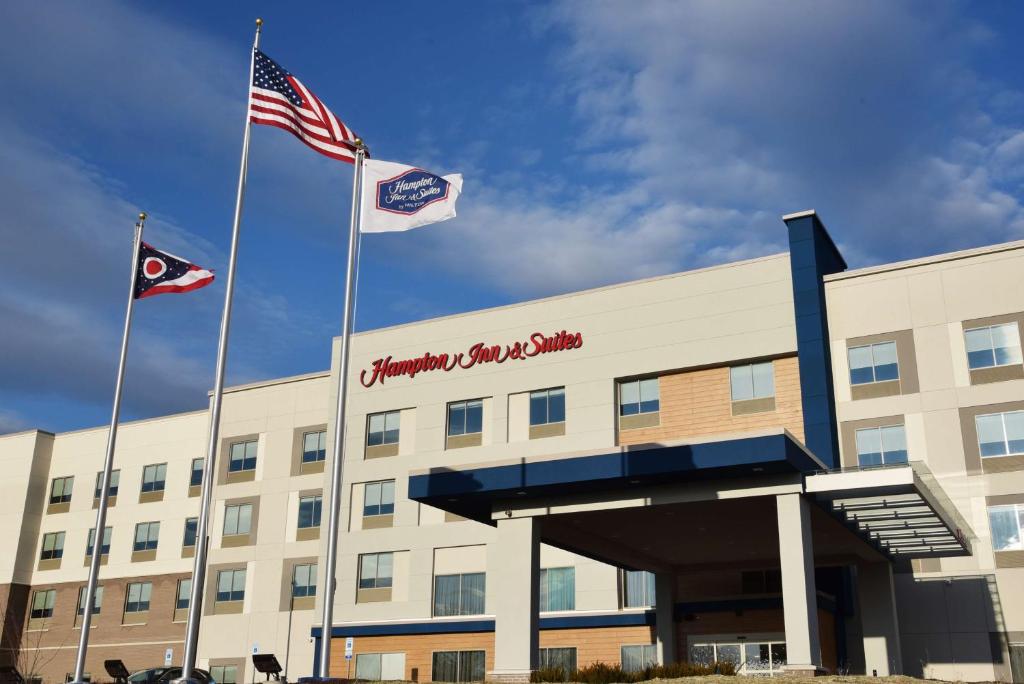 西徹斯特的住宿－Hampton Inn & Suites Cincinnati Liberty Township，两面旗帜在建筑物前飞