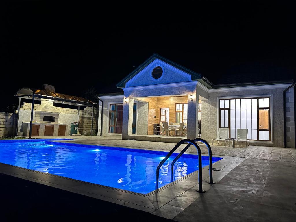 a swimming pool in front of a house at night at Katej in Quba