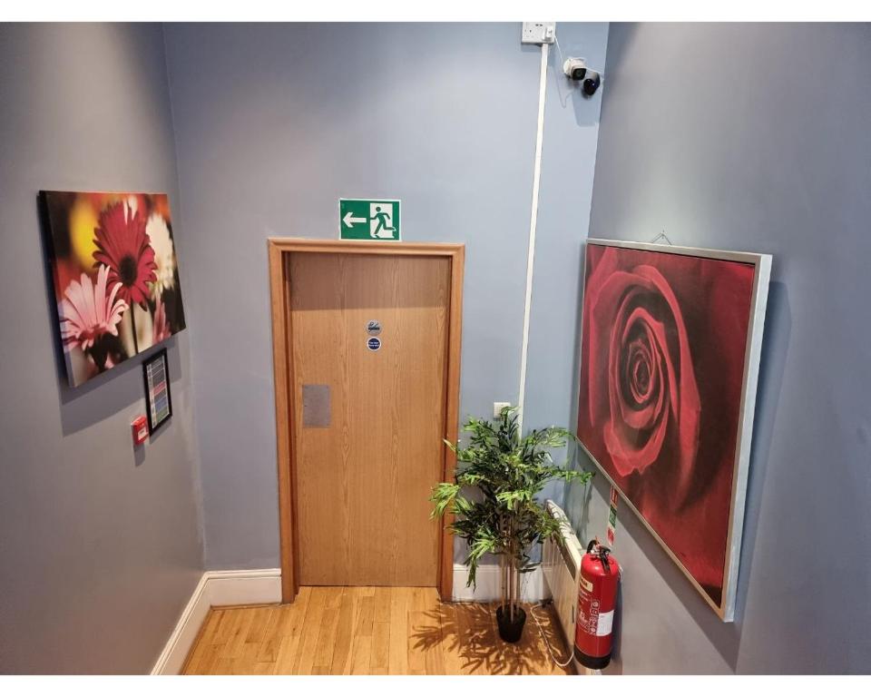 einen Flur mit Holztür und Gemälden an der Wand in der Unterkunft G3- Great Studio for 2 with Patio near Hyde Park in London