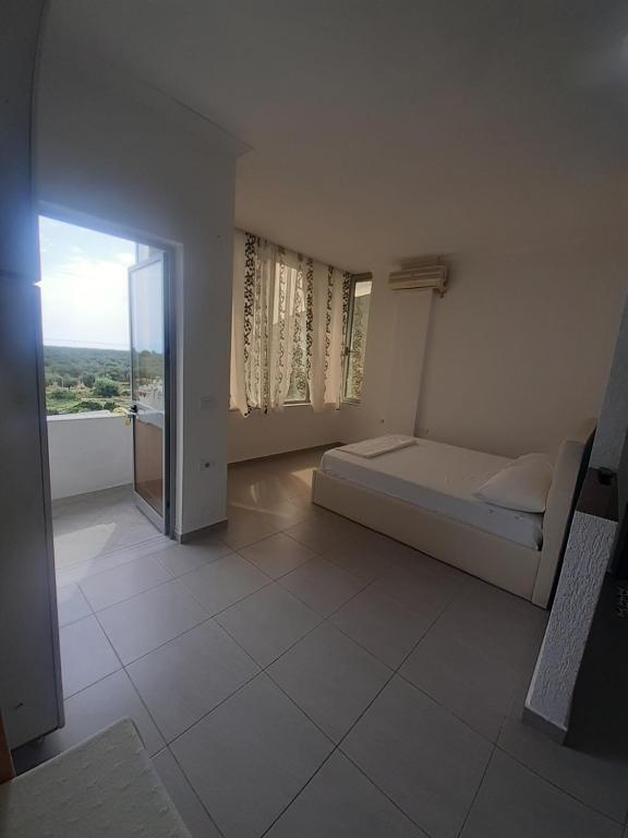 a bedroom with a bed and a large window at Borsh Amantius Apartments in Himare