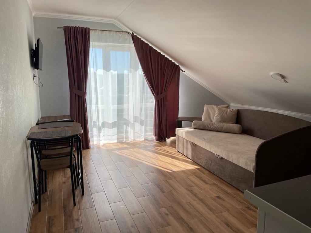 Habitación con cama, mesa y ventana en Yellow apartments en Boryspilʼ