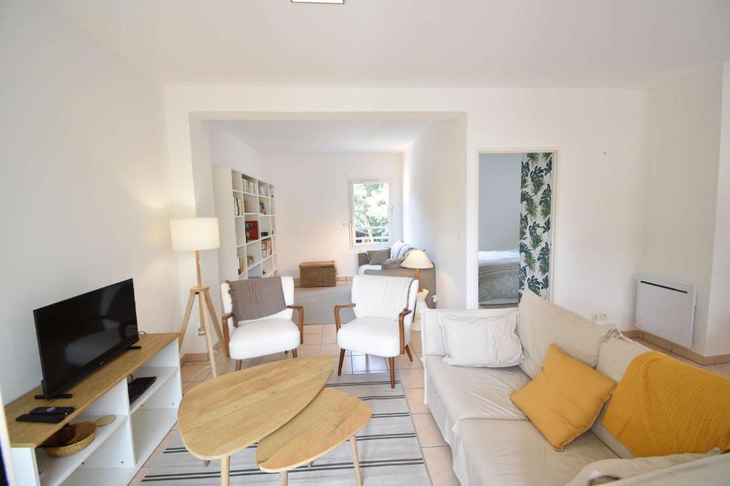 un salon avec un canapé et une télévision dans l'établissement Estrella - Hossegor centre ville magnifique appartement avec parking, à Soorts-Hossegor