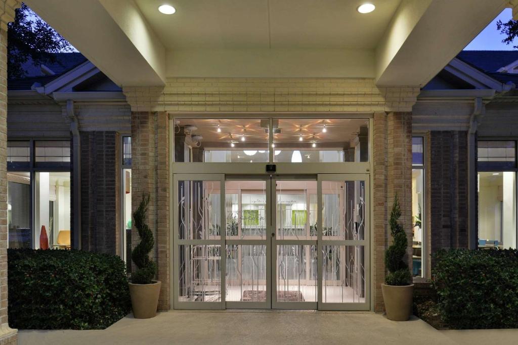 uma porta da frente de um edifício com vidro em Hilton Garden Inn Addison em Addison
