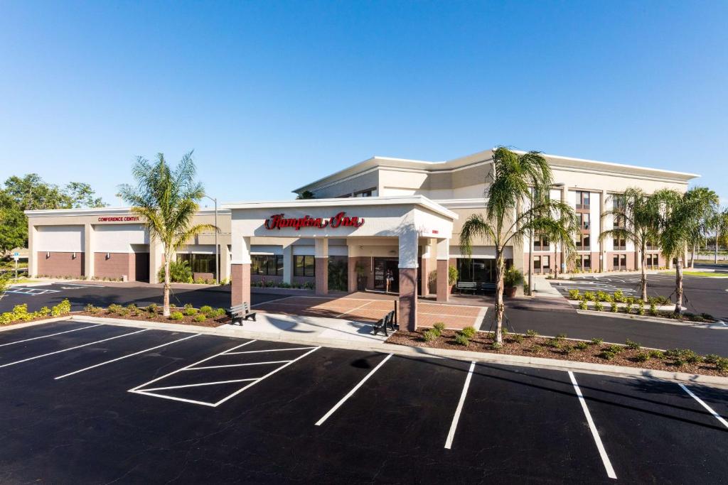 a store front of a shopping center with a parking lot at Hampton Inn Daytona Speedway-Airport in Daytona Beach