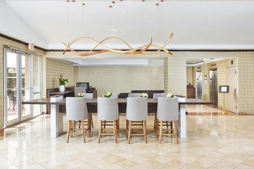 a dining room with a large table and white chairs at DoubleTree by Hilton Dallas Market Center in Dallas