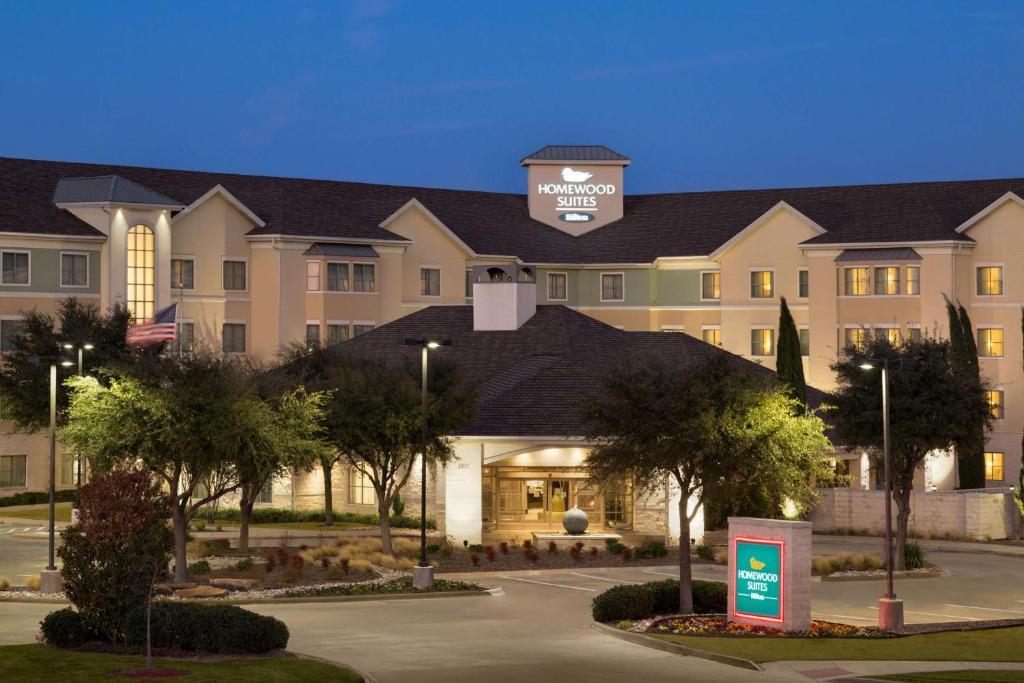 a large building with a sign in front of it at Homewood Suites by Hilton Plano-Richardson in Plano