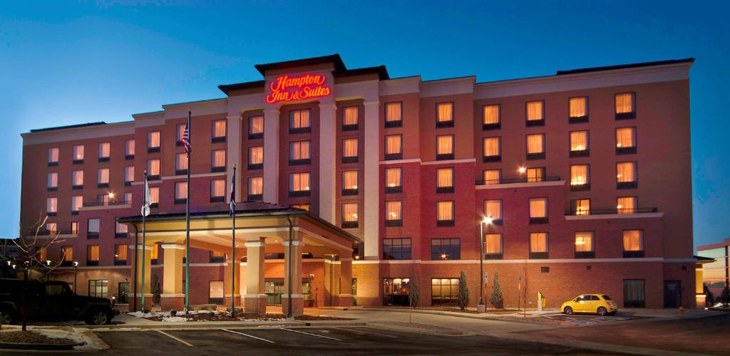 a hotel building with a sign on top of it at Hampton Inn & Suites Denver Airport / Gateway Park in Aurora