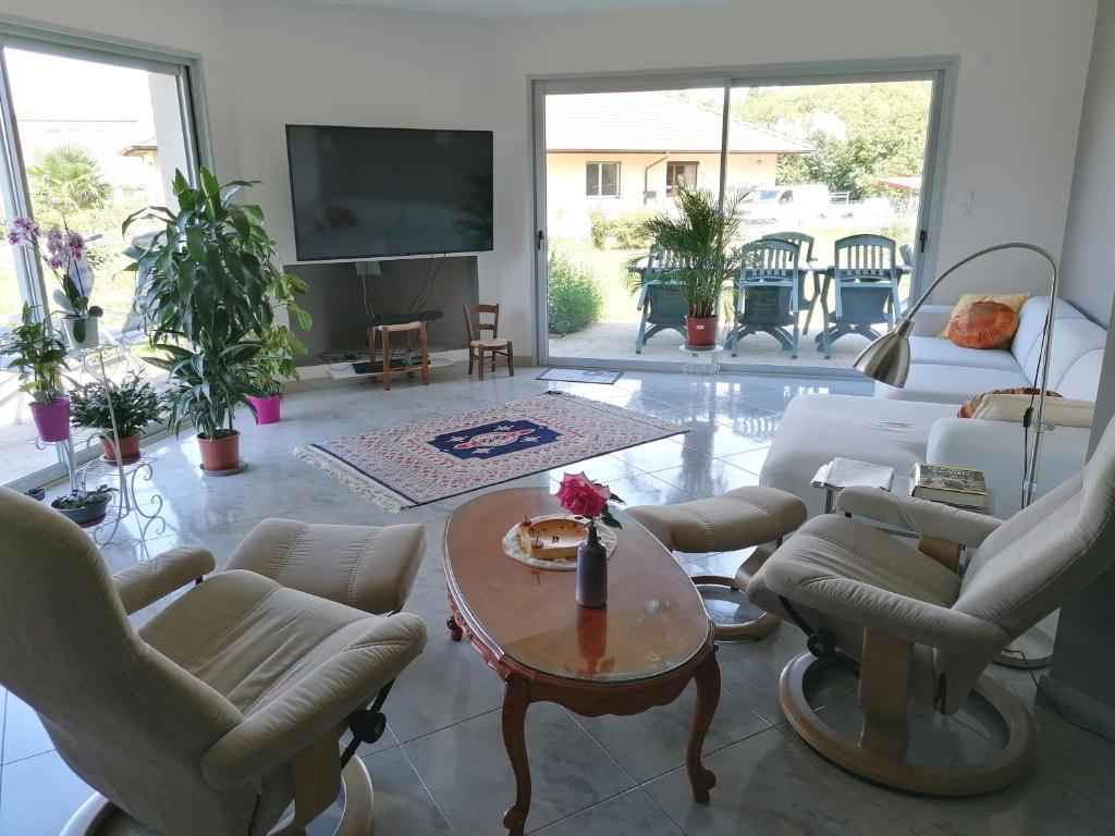 a living room with chairs and a table and a tv at Chambre et table d'hôtes La Meule in Poligny