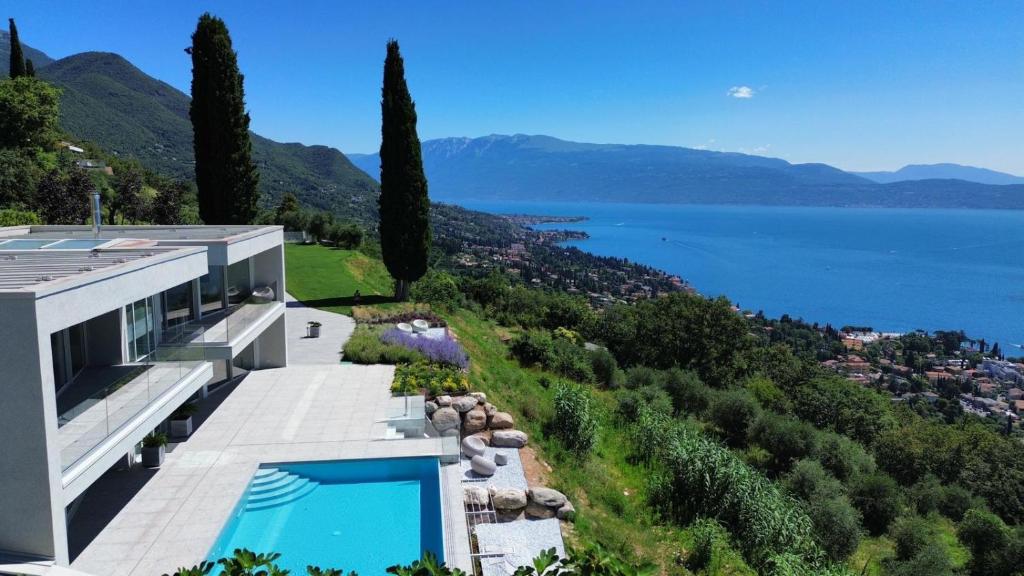 a villa with a swimming pool and a view of the water at Infinity Villa Salò in Salò