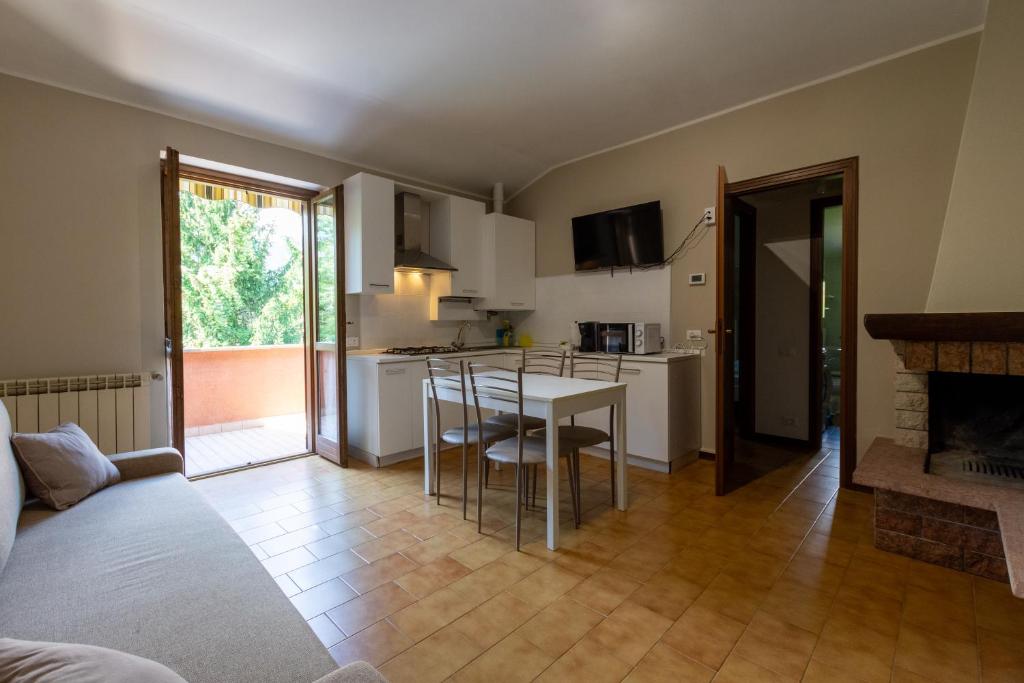 eine Küche und ein Wohnzimmer mit Tisch und Stühlen in der Unterkunft Songavazzo Dream Apartment in Songavazzo