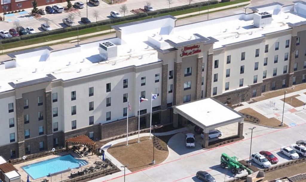 Hampton Inn & Suites Dallas/Ft. Worth Airport South في يوليس: اطلالة علوية على فندق مع مسبح