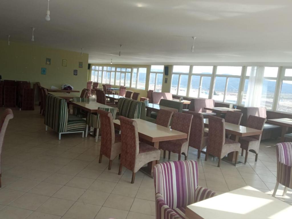 a dining room with tables and chairs and windows at KALECİK OTEL in Kalecik