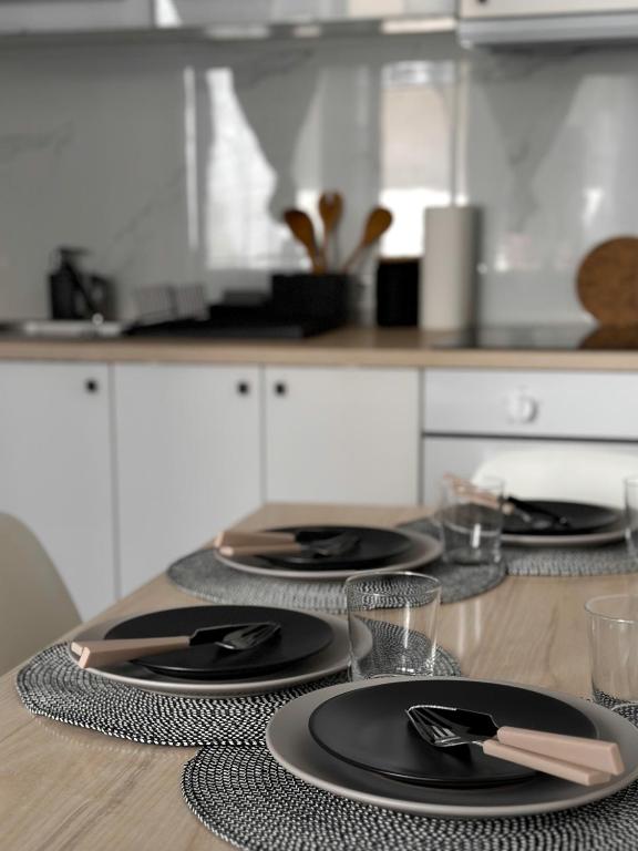 a table with four black plates on a kitchen counter at Dolce Vita House in Budapest