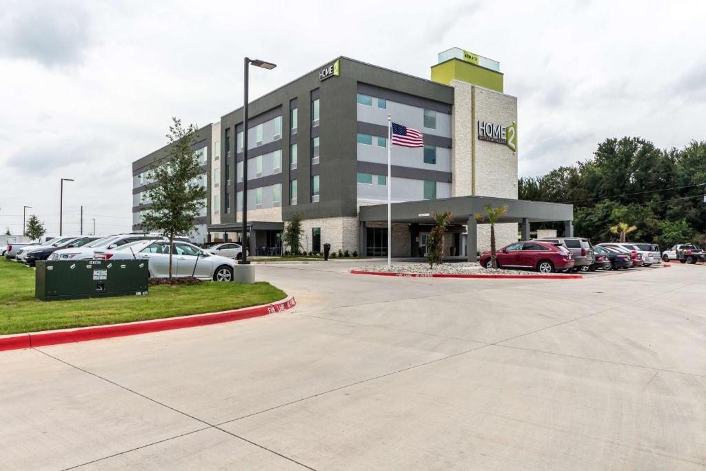 un edificio con coches estacionados en un estacionamiento en Home2 Suites By Hilton Fort Worth Northlake, en Roanoke